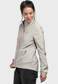 Hellegraue, leichte Jacke mit rosa Reißverschlussakzenten, hoher Kragen, seitlichen Taschen und taillierter Passform. Wasserdichtes Material.