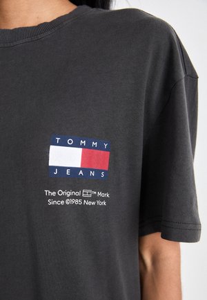 Gray cotton T-shirt featuring a blue, white, and red rectangular logo with "TOMMY JEANS" and brand text in white below. Short sleeves.