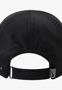 Svart sportkeps av tyg med sydda sömmar, böjd skärm, justerbar bakre rem och en liten Nike-logotyp som detalj.