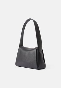 Μαύρη δερμάτινη τσάντα χειρός με λεία υφή, δομημένο σχήμα και φαρδύ λουρί ώμου. Διαθέτει κλείσιμο με φερμουάρ κατά μήκος της κορυφής.