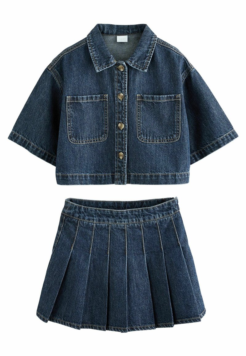 Denim kaksiosainen asu. Lyhyt cropattu napitettava paita, jossa on kaksi rintataskua, lyhyet hihat ja yhteensopiva laskostettu hame. Tumma sininen kangas, jossa on teksturoitu pinta.