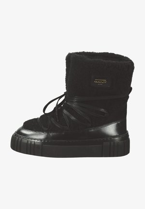 Black high-top boots made of textured wool and leather. Features a thick, ridged sole and black ribbon laces. Logo patch on the side.