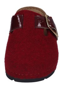 Red felt clog with a glossy maroon strap and gold buckle. Flat sole with stitching detail and a soft inner lining for comfort.