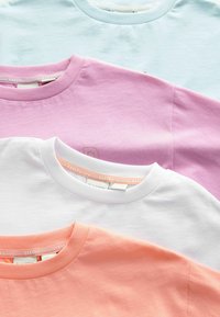 Štyri crewneck tričká usporiadané v prekrývajúcom sa usporiadaní: svetlomodré, levanduľové, biele a koralové. Všetky sú vyrobené z jemnej bavlny s rebrovanými goliermi.