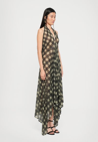 Long, sleeveless dress in olive green and beige plaid pattern. Flowing, asymmetrical design with a soft texture and a deep V-neckline.