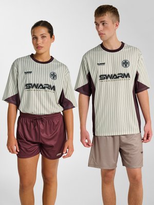 Dwa modele w pasiastych beżowych i bordowych koszulkach sportowych z logo „SWARM”, zestawione z bordowymi i beżowymi szortami, stojący na jednolitym tle.