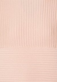 Tissu côtelé rose clair présentant un motif texturé avec des rayures alternant entre lisse et en relief, créant une surface visuellement attrayante.