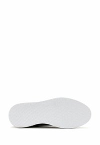 Shoe sole with a textured, white rubber bottom featuring a hexagonal pattern. The upper edge is slightly curved and dark in color.