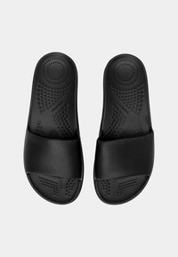 Svarta slidesandaler med en texturerad sula och bred mjuk rem. Tillverkade av syntetiskt material med en slät yta och rund tå.