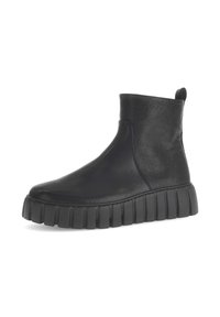 Schwarze Lederstiefeletten mit runder Spitze, elastischem Seitenpaneel und einer dicken, strukturierten Gummisohle mit vertikalen Rillen.