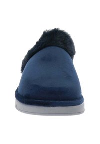 Zapatilla de color azul marino con textura suave, forma redondeada y un acento de piel de fur en la abertura. Presenta una suela plana de goma gris.