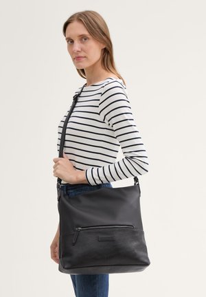 Borsa nera realizzata in pelle e tessuto, con una tasca frontale con zip, tracolla regolabile e superficie liscia, indossata sulla spalla.