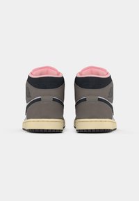 Par de ténis altos com exterior cinza, preto e branco, solas em creme e colarinho acolchoado rosa, vistos de trás sobre um fundo branco.