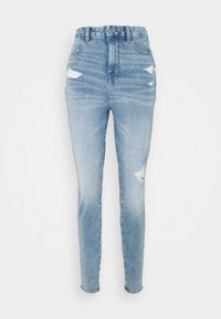 Světle modré džíny s vysokým pasem, s roztrženými detaily, zúženou nohavicí a bledým odstínem. Vyrobené z denimové tkaniny s hladkou texturou.