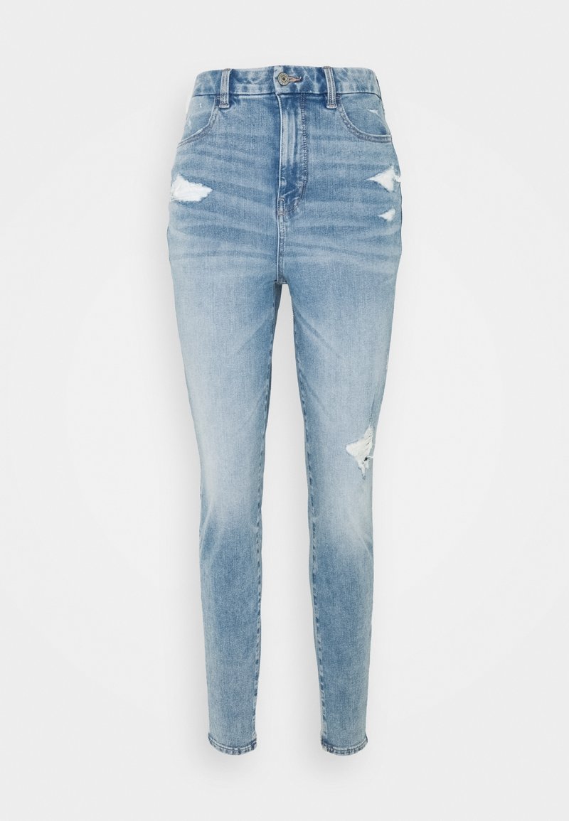 Světle modré džíny s vysokým pasem, s roztrženými detaily, zúženou nohavicí a bledým odstínem. Vyrobené z denimové tkaniny s hladkou texturou.
