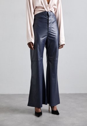 Pantalons évasés en cuir bleu marine à taille haute, avec une fermeture zippée à l'avant, une texture lisse et des coutures minimales.