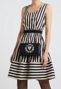 Svart läder crossbody-väska med kedjeskaft, prydd med mångfärgade "LOVE MOSCHINO"-texter och hjärtdesign på framsidan.