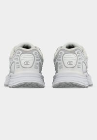 Λευκά αθλητικά παπούτσια με επάνω μέρος από πλέγμα, επενδυμένο γιακά και λαστιχένια σόλα με υφή, με ανοιχτό γκρι λεπτομέρειες και λογότυπο.