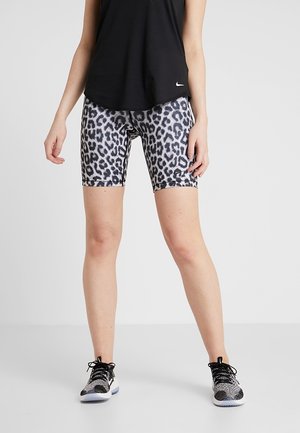 Shorts de cyclisme en imprimé léopard noir et gris, fabriqués en tissu extensible, dotés d'une taille élastique et d'une coupe ajustée. Portés avec un haut noir.