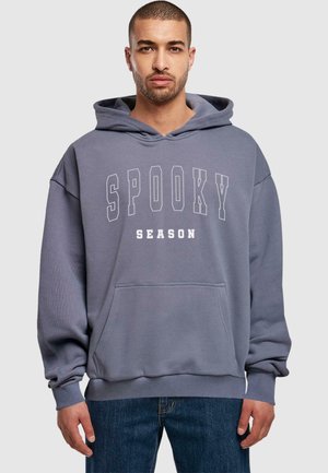 Grå hættetrøje med en kengurulomme, prydet med hvid tekst, der siger "SPOOKY SEASON" i fed skrift. Løs pasform og ribbede ærmer.