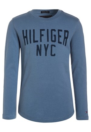 Camisa de algodón de manga larga, de color azul claro, con un cuello redondeado y "HILFIGER NYC" impreso en letras negras en negrita a lo largo del pecho.