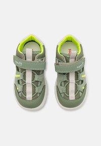 Scarpe da ginnastica verdi con una morbida texture in camoscio, dettagli in mesh, cinturino con chiusura a strap, accentuate da vivaci tocchi di giallo e suole in gomma durevoli.