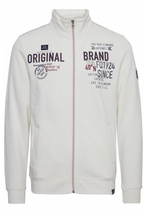 Helles beige Sweatshirt mit Reißverschluss aus weichem Stoff. Verfügt über einen hohen Kragen, zwei Vordertaschen und verschiedene bedruckte Texte in dunklen Farben.