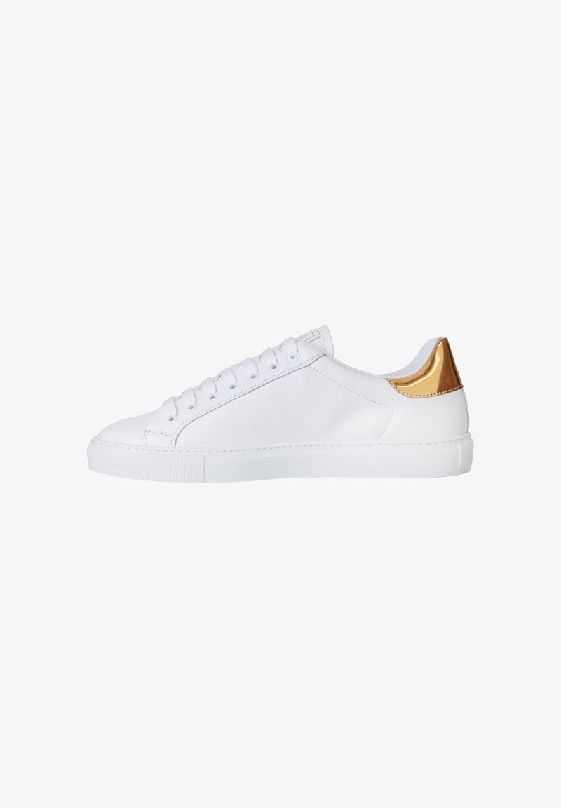 Biały skórzany sneakers z płaską białą podeszwą, zaokrąglonym noskiem oraz złoconym elementem na pięcie. Posiada sześć dziurek na sznurowadła i minimalne przeszycia.