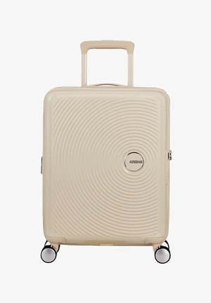 Valigia rigida beige con manico telescopico, quattro ruote girevoli e motivo a cerchi concentrici con logo American Tourister.