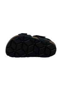 Sole di sandalo nera con motivo geometrico e due cinghie regolabili. Il materiale appare resistente, con una superficie imbottita e testurizzata.