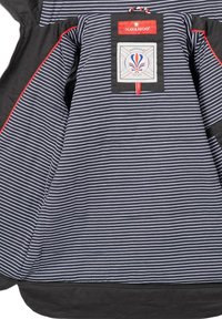 Navy and white striped jacket with a black trim, features a logo patch and red accent stitching. Smooth fabric with a zip closure.