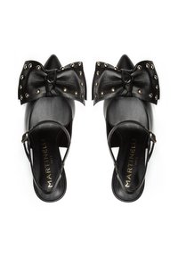 Zapatos negros de tipo slingback con punta afilada, adornados con un gran lazo de cuero y acentos de tachuelas doradas. Tienen una textura suave y una correa para el tobillo ajustable.