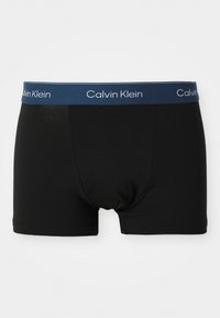 Zwarte boxershorts met een marineblauwe tailleband waarin de witte "Calvin Klein" branding is verwerkt. Gladde katoenen stof met een aansluitend ontwerp.