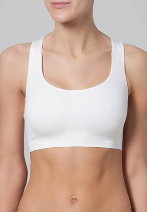 Sport bra bianco con scollatura a giro, spalline larghe, tessuto morbido e design aderente che si estende fino alla vita.