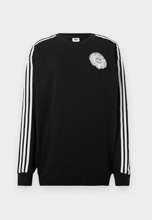 Sudadera negra con rayas blancas en las mangas y un parche decorativo de flor gris en el pecho. Puños acanalados y diseño de cuello redondo.