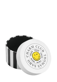 Contenitore rotondo con coperchio bianco decorato con un volto sorridente giallo. I lati sono a strisce bianche e nere, con una finitura liscia.