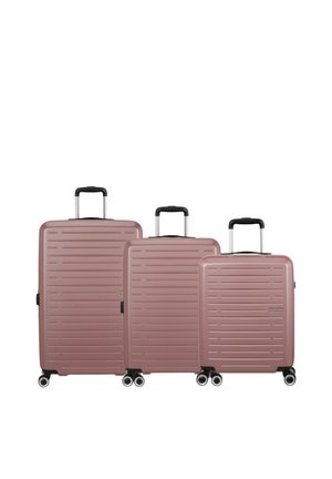 Tre valigie rigide color oro rosa con scanalature orizzontali, maniglie nere e quattro ruote, disposte dalla più grande alla più piccola.