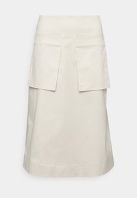 Gonna beige a lunghezza cura, realizzata in tessuto morbido, con due grandi tasche frontali e un design dritto. Stile minimalista con linee pulite.