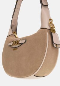 Beige Wildleder Schultertasche mit glatten Lederakzenten, goldfarbener Hardware und einem doppelten Kettendetail auf dem Deckel. Texturierte, abgerundete Form.
