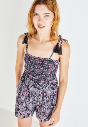 Romper floreale nero con motivi rosa e blu, dotato di corpino arricciato, spalline legate con ponpon e un taglio corto rilassato.