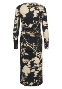 Vestido de manga larga en negro con un patrón floral en crema. Presenta detalles fruncidos en la parte posterior y una tela suave y elástica.