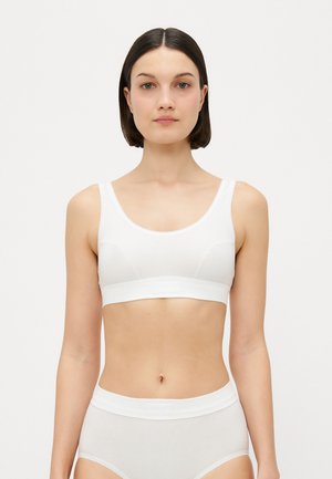 White cotton bra with wide straps, round neckline, and seamless design. Paired with matching white high-waisted panties, smooth texture.