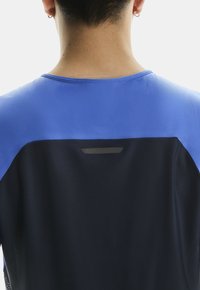 Koszulka sportowa z krótkim rękawem, z niebieską górą i ciemnonawowym dołem, z teksturowanej tkaniny i odblaskowym akcentem z tyłu.