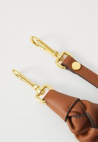 Braided brown leather strap featuring gold hardware and a circular rivet. Includes two gold clasp attachments. Smooth texture.