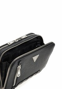 Zwarte leren tas met structuur, zilveren hardware, dubbele ritssluitingen en een driehoekig logo met merknaam. Het interieur heeft een patroonvoering.