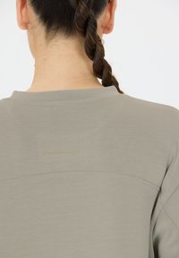 Lichtgrijs sportshirt met een ronde hals, textuurstof en een subtiele gouden "ENDURANCE" logo op de achterkant.