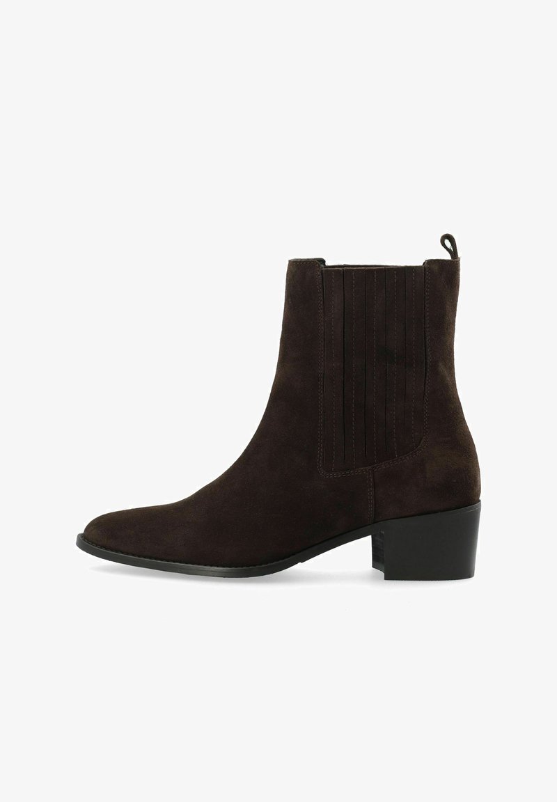 Brūnas zamšādas potīšu zābaki ar nedaudz norādītu purngalu, elastīgām sānu paneļiem un zemu blokveida papēdi. Gluda tekstūra ar smalkām adījuma detaļām.