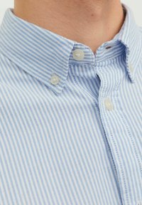 Hellblau-weiß gestreifte Button-Up-Hemd mit klassischem Kragen, ausgestattet mit Kunststoffknöpfen und einer weichen Textiloberfläche.