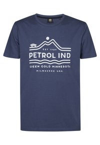 T-shirt in cotone blu navy con una stampa grafica bianca che raffigura montagne, un sole e il testo "PETROL IND" con dettagli sulla località. Maniche corte.
