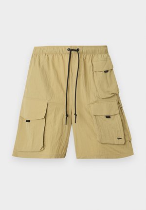 Beige cargo sortok könnyű szövetből. Több oldalsó zsebbel, gumis derékkal és megkötővel, valamint egy kis logóval rendelkezik.